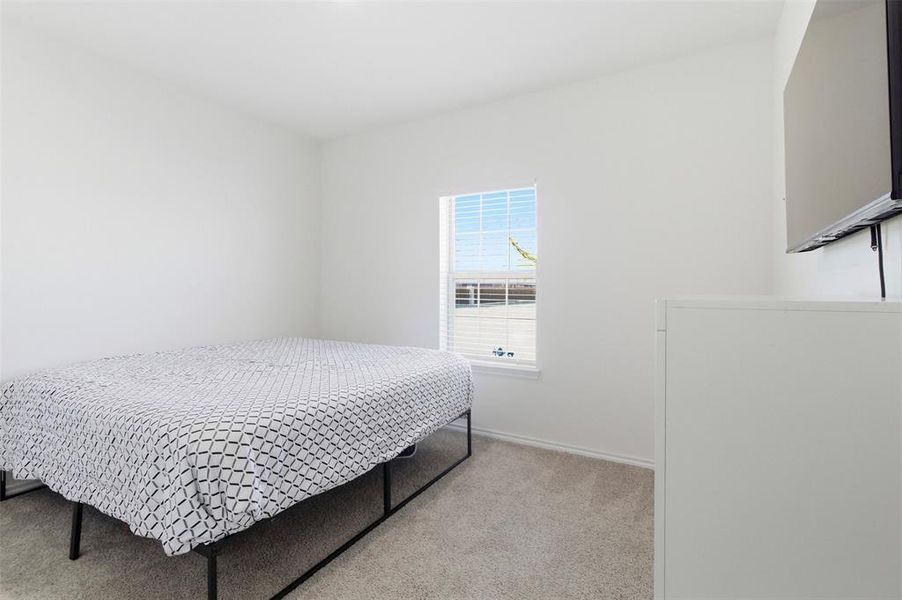 Bedroom featuring light carpet and baseboards Bedroom featuring light carpet and baseboards