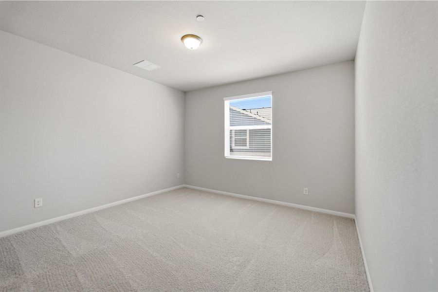 Spare room with light colored carpet and baseboards