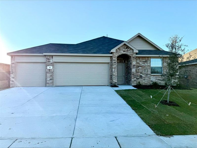 View of front of home featuring a front yard and a garage