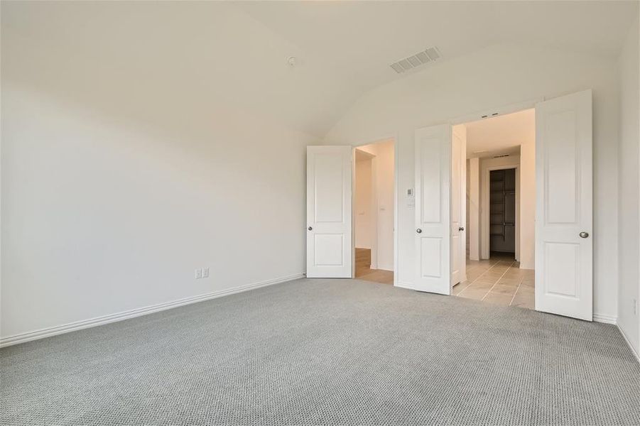 Empty room featuring lofted ceiling and light colored carpet