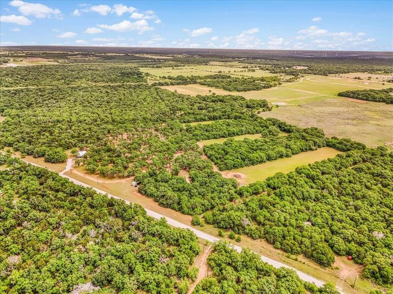 Expansive rural landscape featuring dense tree coverage and open clearings