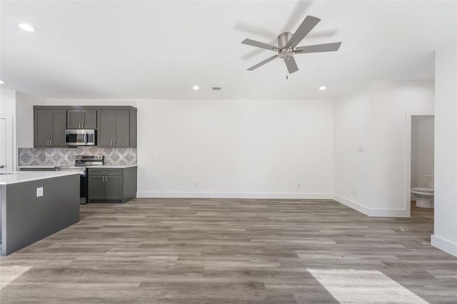 Kitchen featuring backsplash, recessed lighting, light wood-style floors, appliances with stainless steel finishes, and a ceiling fan