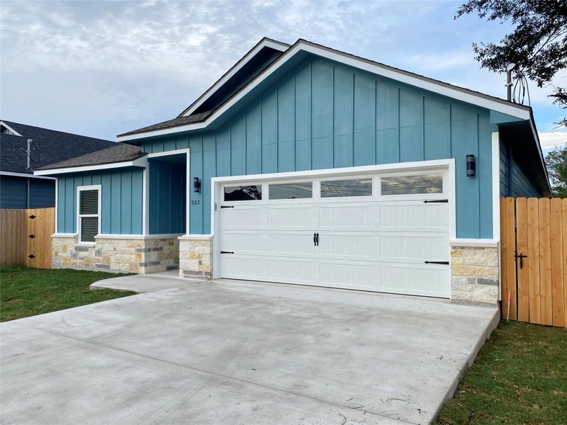 A striking exterior combines board and batten siding with stone accents and a pristine driveway.