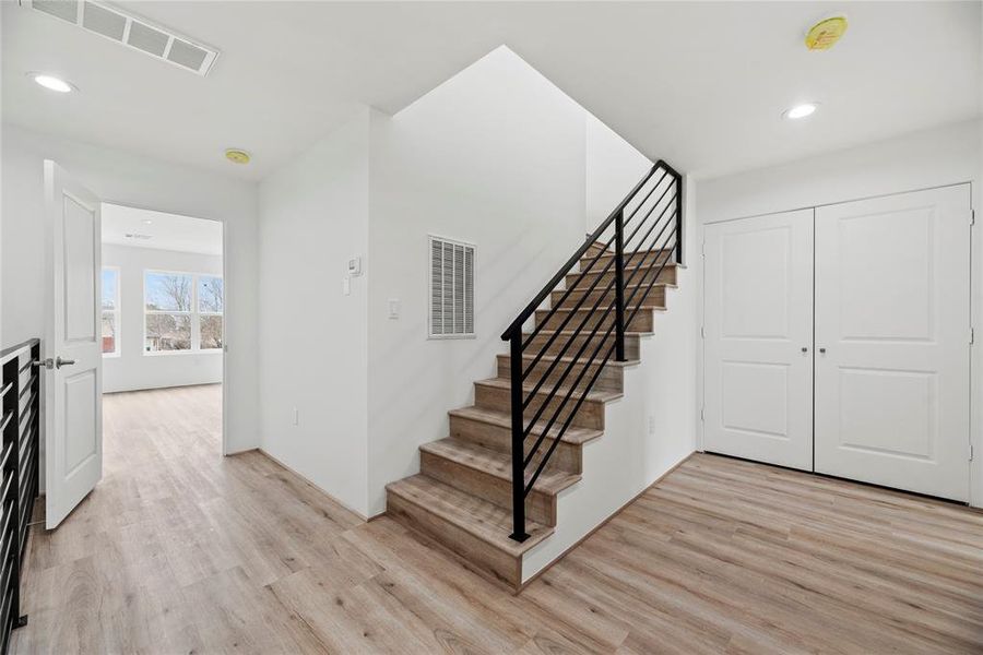 Clean, modern staircase rails blend perfectly with the Luxury Vinyl plank flooring.