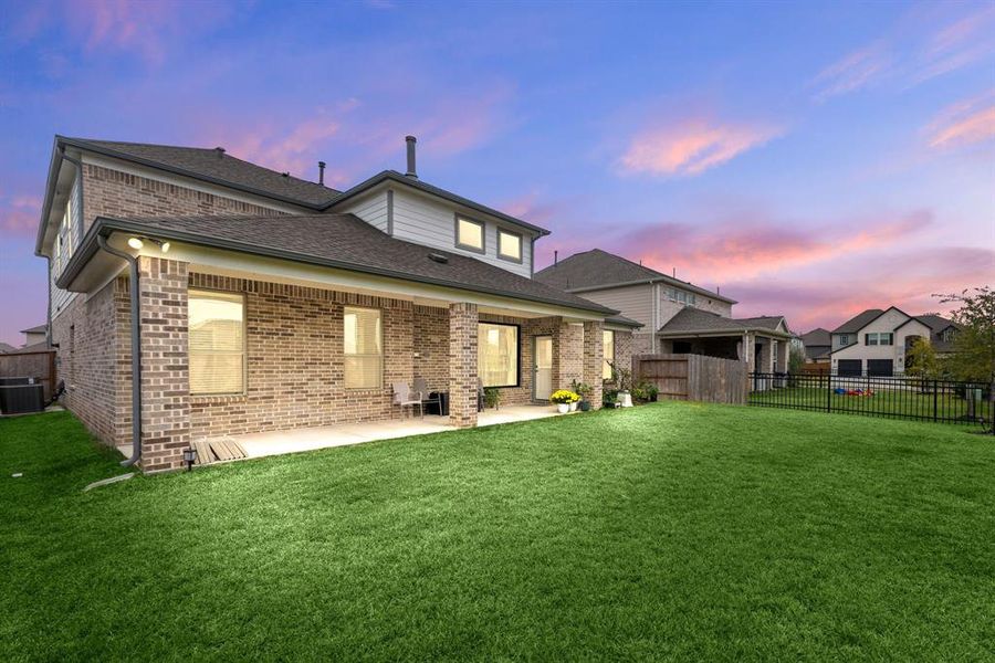 A sturdy and stylish 4-sided brick home with a covered patio.