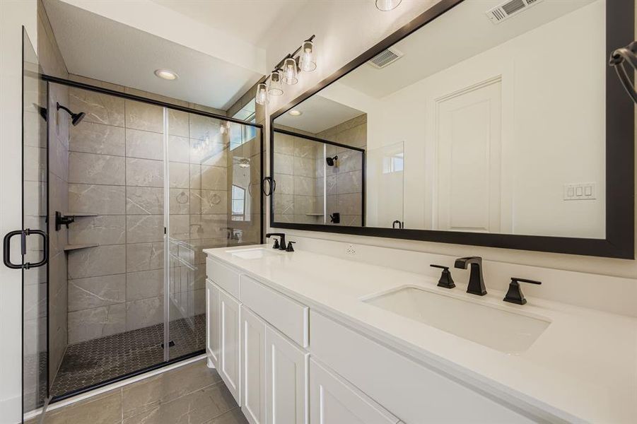 Full bath with a stall shower, double vanity, recessed lighting, and light tile patterned floors