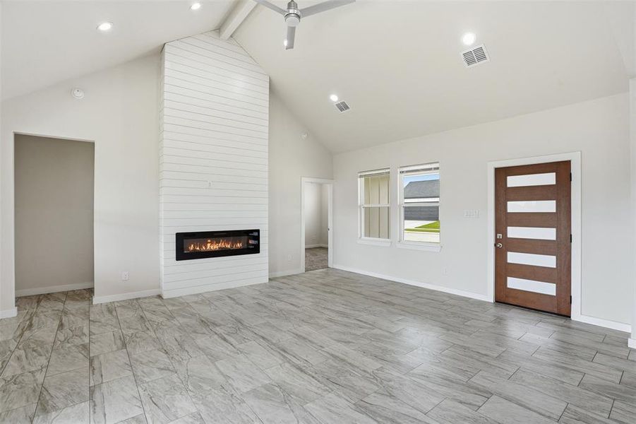 Vaulted ceilings over an open-concept living area with plank-style flooring