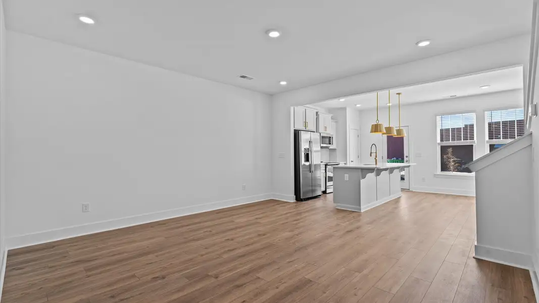 Spacious family room with rich hardwood flooring and elegant trim work in a reputable DRB Homes build