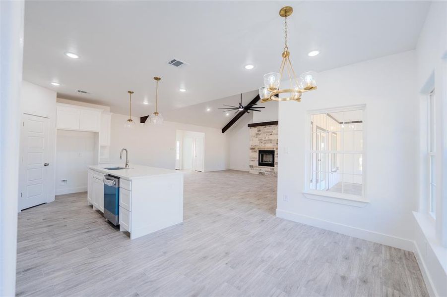 Kitchen with pendant lighting, ceiling fan, a chandelier, white cabinets, and lofted ceiling Kitchen with pendant lighting, ceiling fan, a chandelier, white cabinets, and lofted ceiling