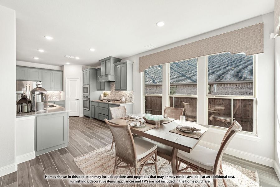 Open dining area with wood table and chairs next to large windows, adjoining kitchen with gray cabinets and tile backsplash. Open dining area with wood table and chairs next to large windows, adjoining kitchen with gray cabinets and tile backsplash.