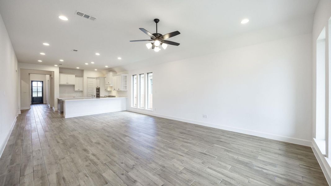 Unfurnished living room with a ceiling fan, light wood-style floors, and recessed lighting Unfurnished living room with a ceiling fan, light wood-style floors, and recessed lighting