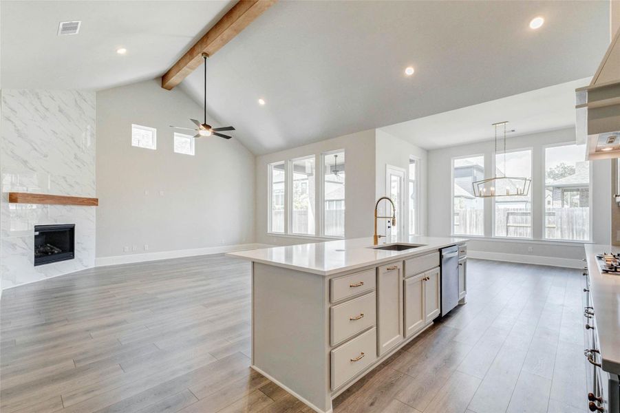 Open-concept living space features high ceilings with wooden beam, and large windows for natural light.
