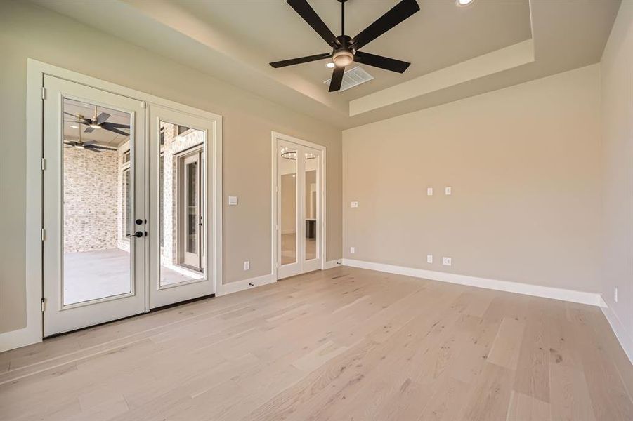 Unfurnished room featuring french doors, light wood-type flooring, and ceiling fan