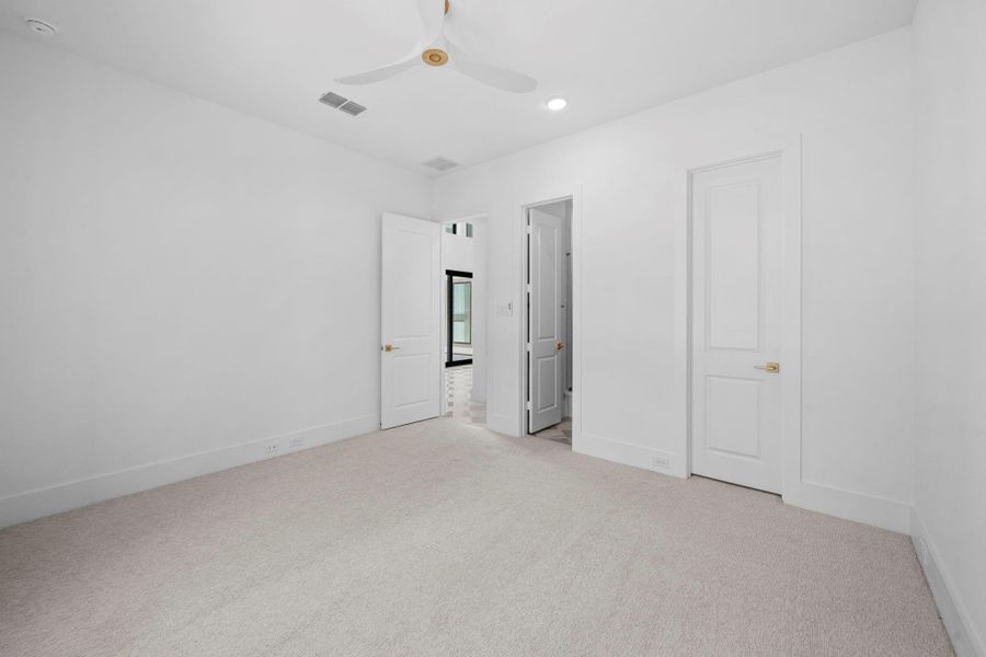 Spacious bedroom featuring soaring ceilings, large windows, and a bright, airy atmosphere.
