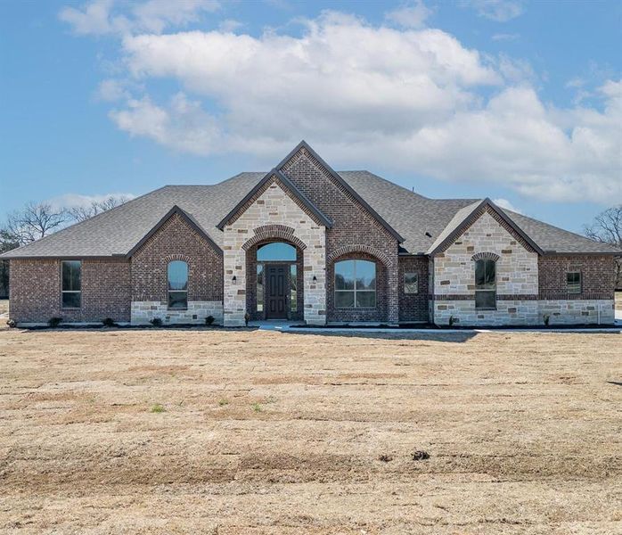 Prior listing photo. Property remains accurate - French provincial home featuring brick siding, stone siding, and roof with shingles.