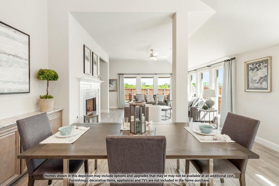Open-concept dining area with wood table flowing into living room with fireplace and vaulted ceiling Open-concept dining area with wood table flowing into living room with fireplace and vaulted ceiling