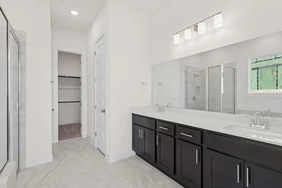 Full bath featuring a marble finish shower, double vanity, a walk in closet, and recessed lighting Full bath featuring a marble finish shower, double vanity, a walk in closet, and recessed lighting