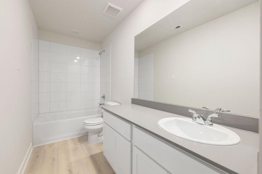 This inviting secondary bedroom features soft tones, elevated ceilings, and a large window that fills the space with natural light. Ideal for guests or family, it offers both comfort and versatility.