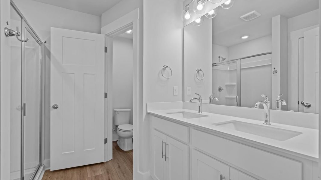 Notable primary suite with dual vanities and walk-in shower in this prime Spartanburg townhome Notable primary suite with dual vanities and walk-in shower in this prime Spartanburg townhome