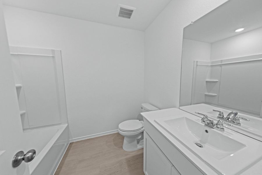 Full bath featuring vanity, light wood finished floors, and shower combination Full bath featuring vanity, light wood finished floors, and shower combination