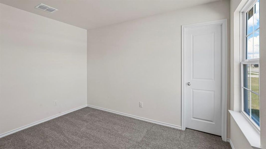 Room featuring light-toned walls, grey carpet flooring, white baseboards, a single window, and a paneled white door with a round doorknob