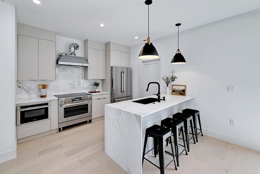 Kitchen featuring a breakfast bar, a peninsula style island, Bosch appliances with stainless steel finishes, and decorative backsplash