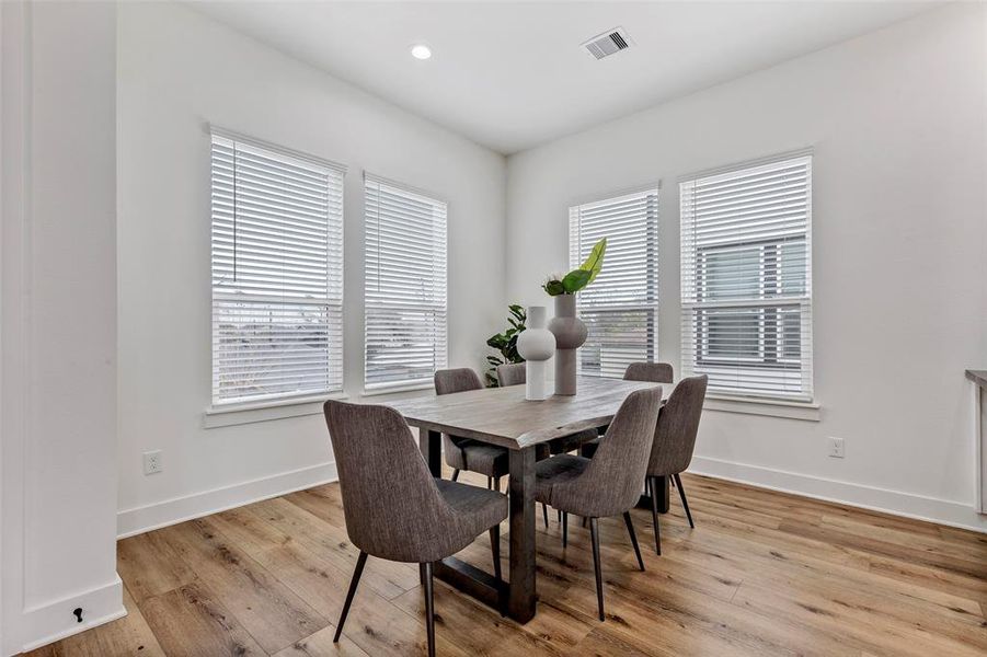 Cozy formal dining area with beautiful floors and plenty of natural light, creating the perfect setting for family meals and entertaining.