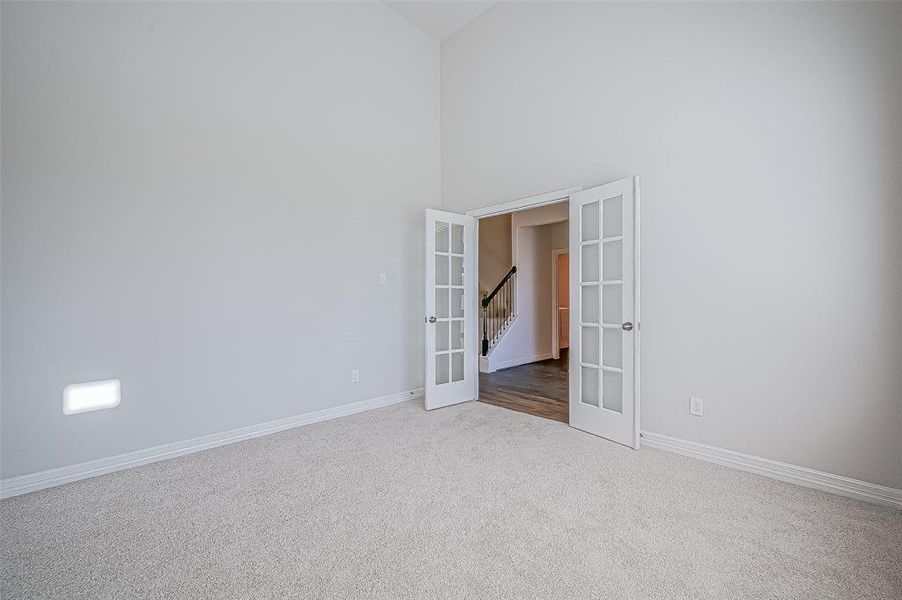 French doors open to a private study/home office with high ceilings.