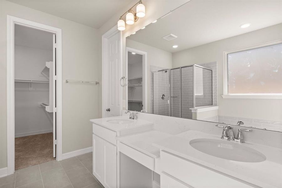 The en-suite bathroom offers a spa-like atmosphere with its elegant design, high end finishes, and tasteful lighting, creating a retreat within your own home.