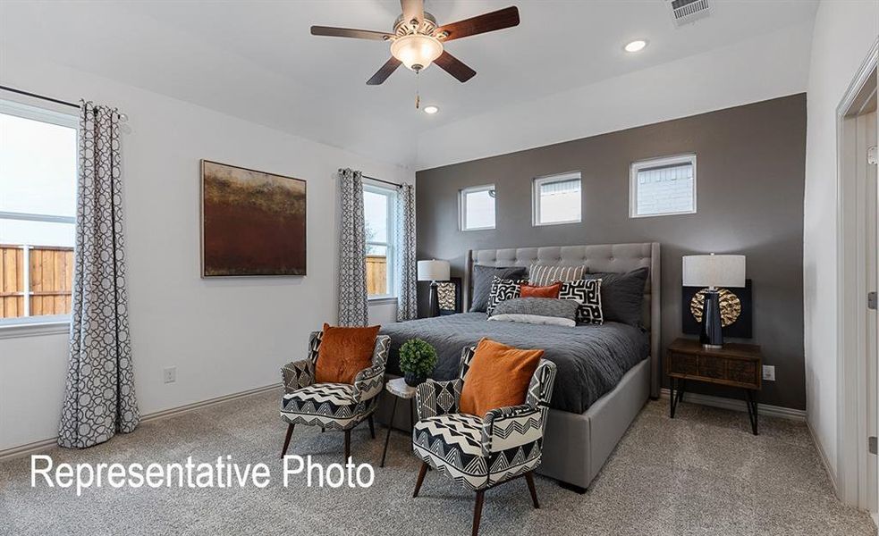 Bedroom with carpet, vaulted ceiling, multiple windows, and ceiling fan