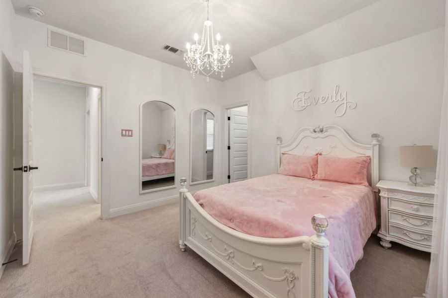 Carpeted interior room featuring a decorative chandelier, and walk in closet