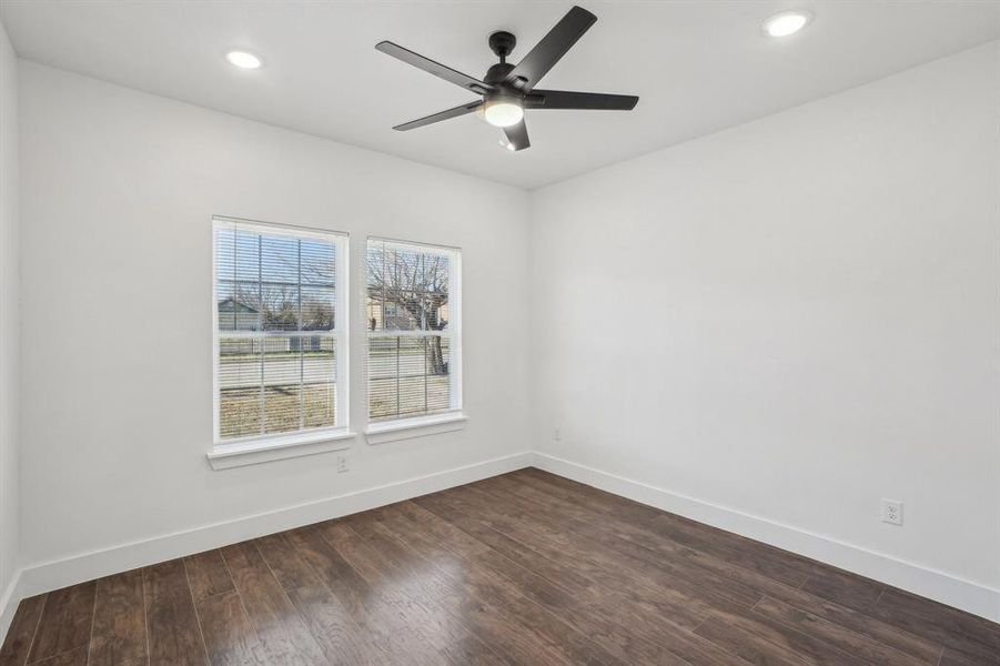 Front bedroom 2 featuring walk-in closet, dark hardwood / wood-style flooring and ceiling fan