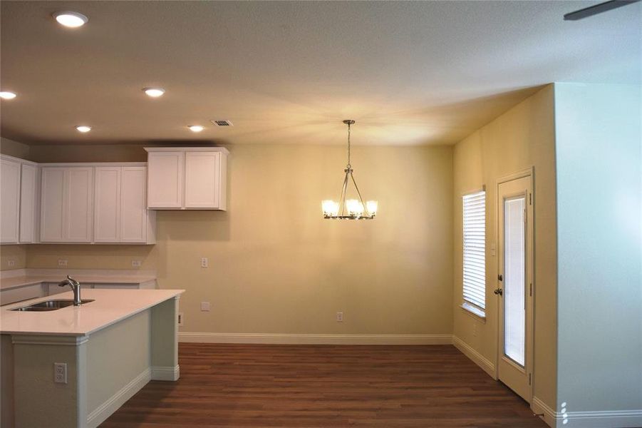 Kitchen with white cabinetry, a chandelier, recessed lighting, dark wood-type flooring, and hanging light fixtures
