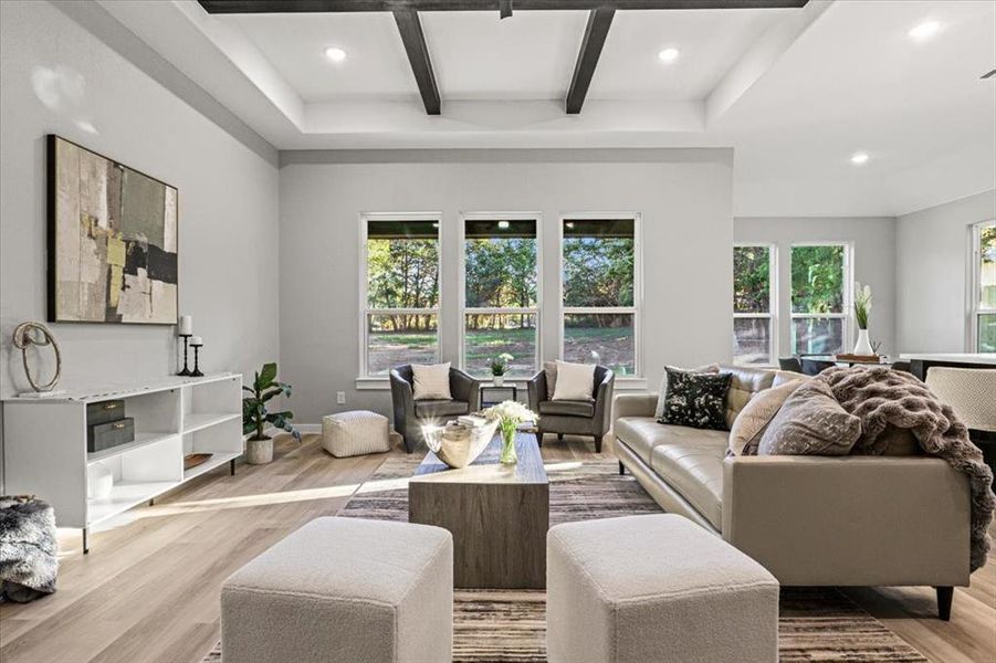 Living room with beamed ceiling and light hardwood / wood-style flooring