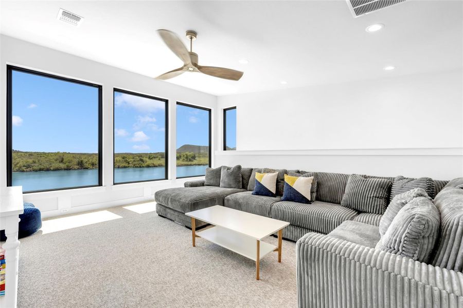 Living room three: Soaring ceilings and massive windows framing peaceful water views define this airy living space.