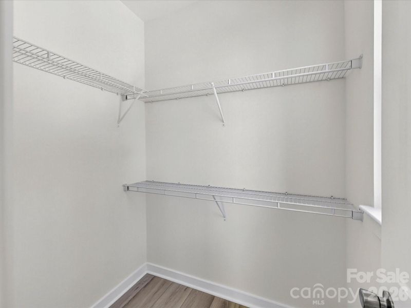 Spacious walk-in primary closet with ample storage and room for organized, everyday living.