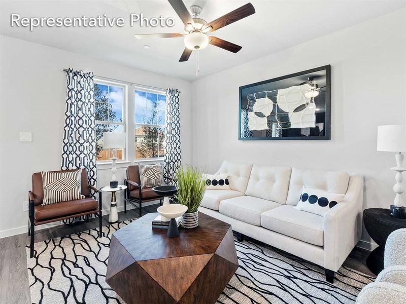 Living room with ceiling fan and light hardwood / wood-style floors