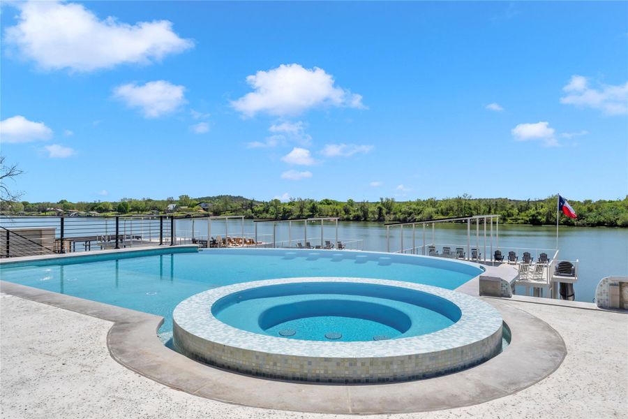 An elevated pool deck overlooks the serene waterfront on a clear day.