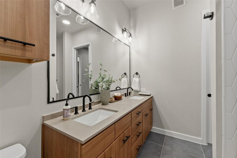 Bathroom with double vanity and tile patterned flooring