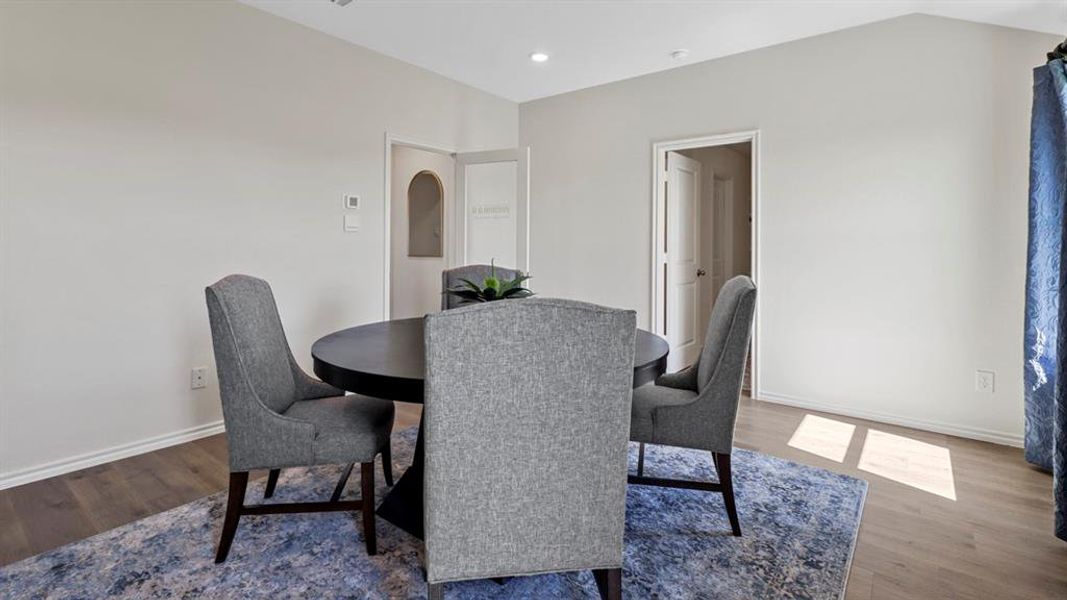 Dining space with wood finished floors and recessed lighting