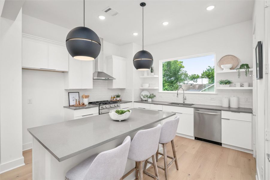 A striking oversized island takes center stage in this thoughtfully crafted kitchen.