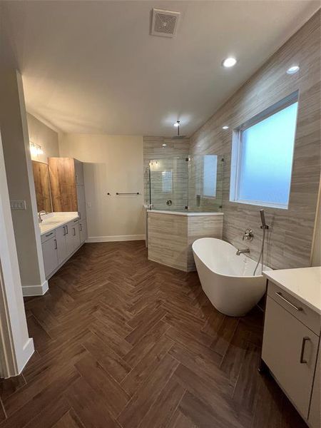 Bathroom featuring separate shower and tub and vanity