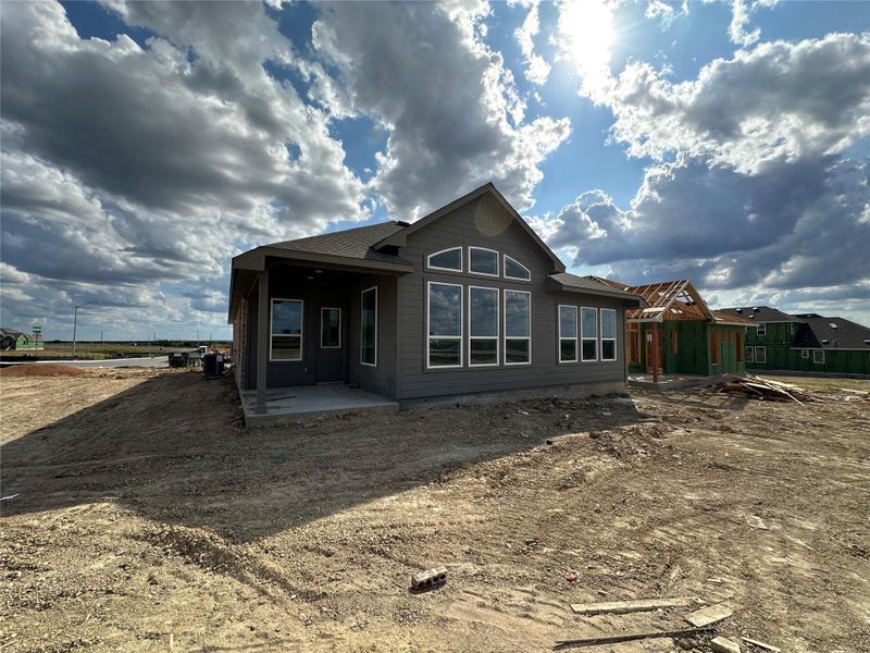 Newly constructed residence with expansive windows and a dark exterior offers a modern aesthetic amidst open land. Newly constructed residence with expansive windows and a dark exterior offers a modern aesthetic amidst open land.