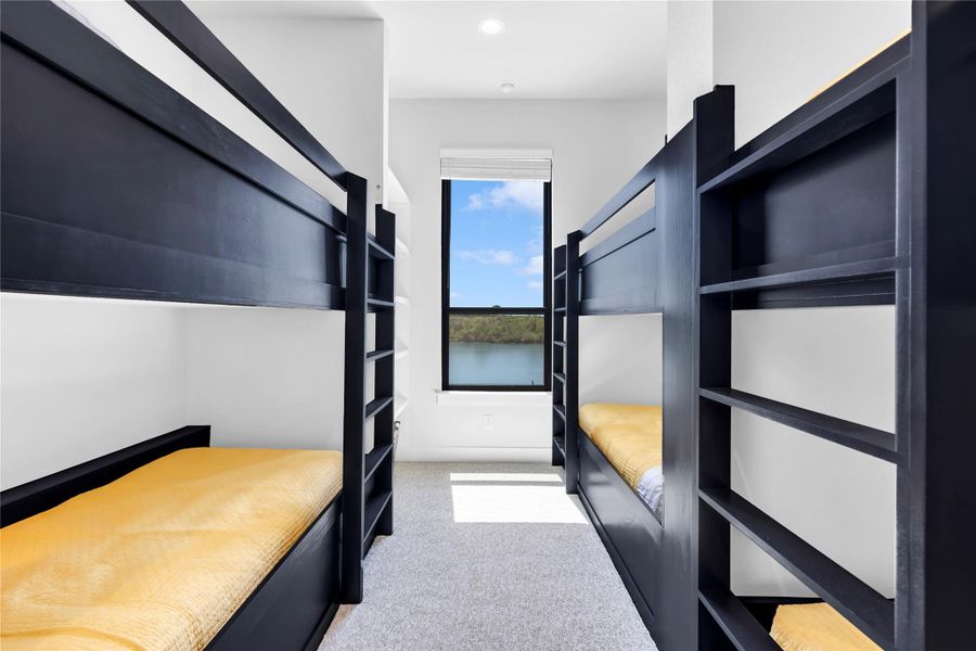 Bedroom seven: Custom built-in bunk beds flank a window frame framing serene water views.