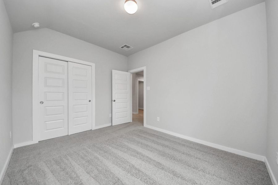 Generously sized secondary bedrooms featuring spacious closets, soft and inviting carpeting underfoot, large windows allowing plenty of natural light, and the added touch of privacy blinds for your personal retreat. Sample photo of completed home with similar floor plan. Actual colors and selections may vary.