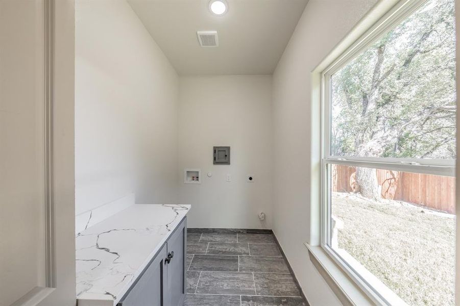Laundry room with hookup for an electric dryer, hookup for a washing machine, recessed lighting, and cabinet space