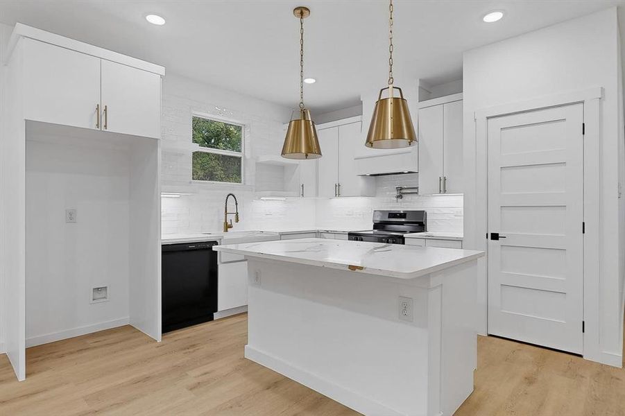 Kitchen with white cabinetry, tasteful backsplash, light wood finished floors, a center island, and recessed lighting Kitchen with white cabinetry, tasteful backsplash, light wood finished floors, a center island, and recessed lighting