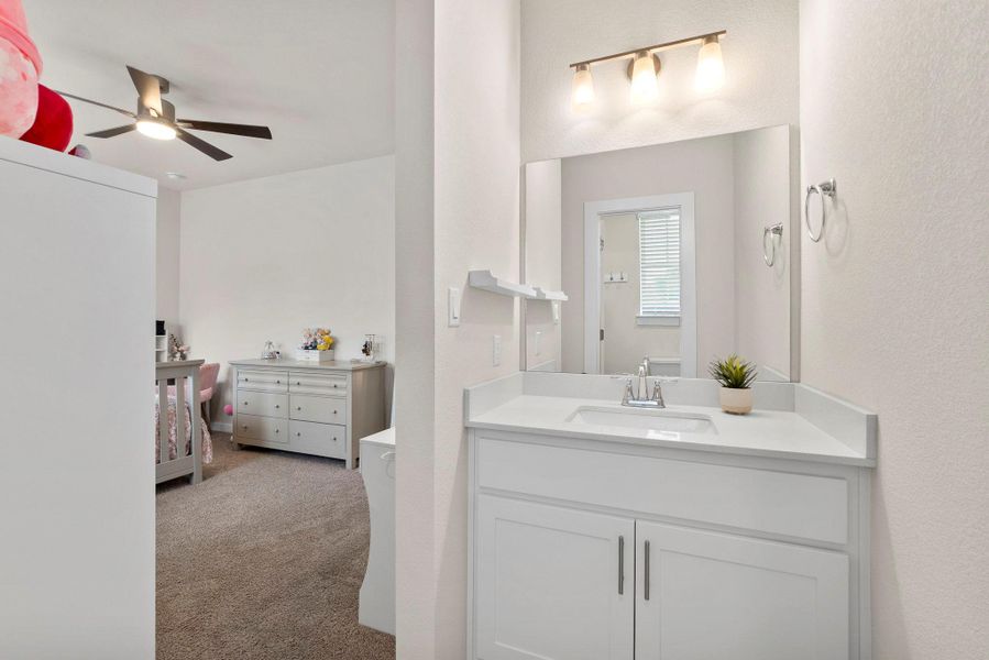 White vanity with a rectangular undermount sink and light-toned countertop