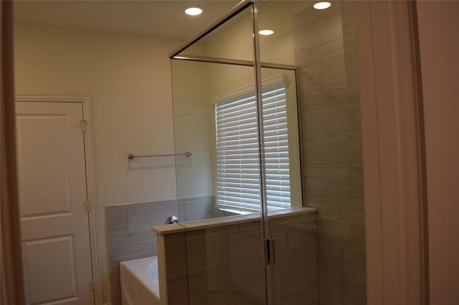 Bathroom featuring a shower stall, a garden tub, recessed lighting, and plenty of natural light