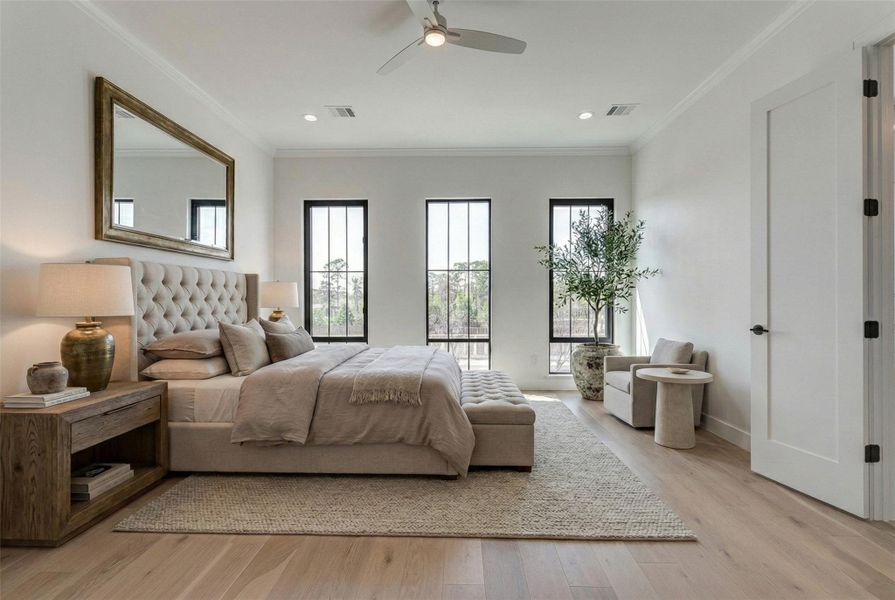 Expansive third-floor primary suite featuring engineered wood flooring, crown molding, recessed lighting, and three tall black-framed windows that fill the space with natural light. The generous layout easily accommodates a king-sized bed and seating area, creating a serene private retreat. This photo has been virtually staged for visual reference.